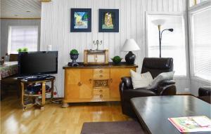 a living room with a couch and a television at Five-Bedroom Holiday Home In Vikesa in Hovland