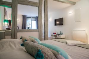 a bedroom with two beds and a tv on the wall at Grand studio Colmar Centre in Colmar