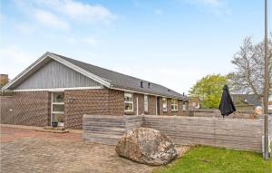 a brick house with a fence and a rock at Nice Apartment In Bindslev With Wifi in Bindslev +7 photos