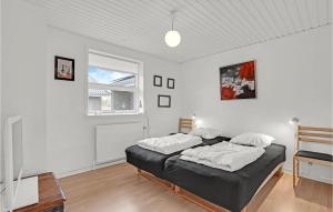 a bedroom with two beds and a television in it at Nice Apartment In Bindslev With Wifi in Bindslev