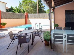 a patio with tables and chairs next to a pool at Casa La Palmera in Dúrcal