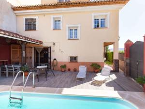 a villa with a swimming pool in front of a house at Casa La Palmera in Dúrcal