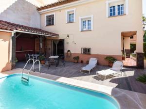 a swimming pool in front of a house at Casa La Palmera in Dúrcal