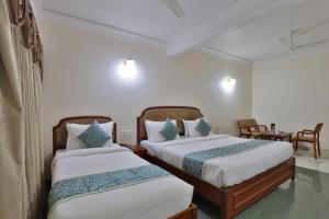 Un dormitorio con dos camas y una mesa. en Hotel Yadgar, en Surat 32 fotos más