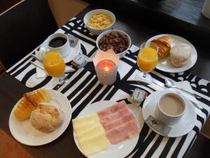 una mesa con platos de comida y bebida para el desayuno en Dear Porto Guest House, en Oporto