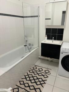 a bathroom with a sink and a washing machine at ORCHIDÉES CHOISY 5Pers Parking Wifi in Choisy-le-Roi +15 photos