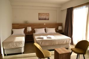ein Schlafzimmer mit zwei Betten und einem Tisch und Stühlen in der Unterkunft ALPHA APARTMENTS Free Shuttle from and to the Airport in Spáta