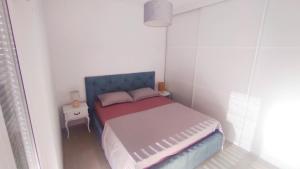 a small bedroom with a bed and a table at Apartman Marta in Split