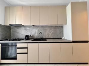 a kitchen with white cabinets and a sink at Cozy Apartment in Bucharest