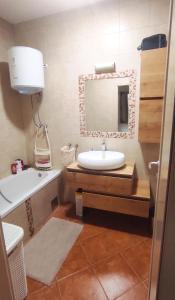 a bathroom with a sink and a mirror and a tub at Apartman Marta in Split +10 photos