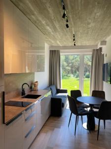 a kitchen and living room with a table and chairs at Monciskes Apartment Seaside in Palanga