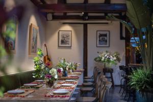 a long table in a room with chairs and flowers at Peking Yard Siheyuan Boutique Hotel &Garden&Terrace&Lama Temple&hutong&Houhai&Tiananmen&Bistro in Beijing