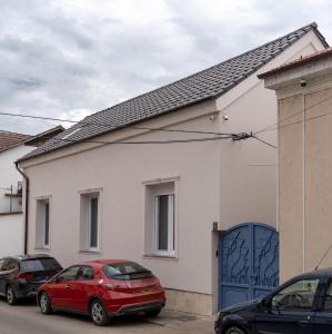 a red car parked in front of a white house at Poema in Oradea