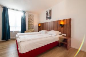 ミュンヘンにあるHotel Astorの木製のヘッドボードが付いた大きなベッドのある寝室