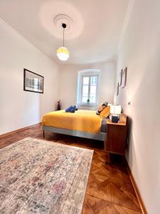 a bedroom with a yellow bed and a window at Suite Mitteleuropa private parking in Trieste