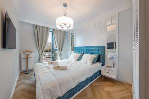 a bedroom with a large bed with a blue headboard at Blue Apartment - Tarasy Bałtyku in Gdańsk