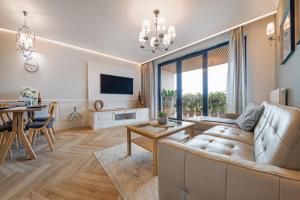 a living room with a couch and a table at Blue Apartment - Tarasy Bałtyku in Gdańsk