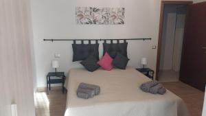 a bedroom with a large bed with pink and black pillows at Appartamento centrale in Lido di Ostia
