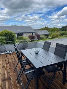 a black table and chairs on a deck at Les Quartiers d'Urbain in Nollevaux