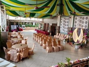 a restaurant with tables and chairs and a large tent at Hotel Pushpak in Bhubaneshwar