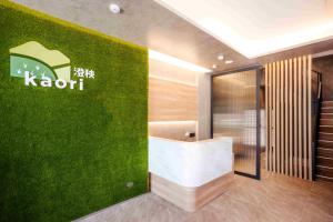 un muro verde con un cartello kishi sopra di kaori B&B a Chishang