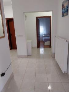 Apartman Ana Zadar - FAMILY FRIENDLY APARTMENT في زادار: ممر به غرفة بها سرير وأرضية من البلاط