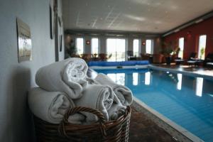 a basket of towels next to a swimming pool at Örums Nygård Gårdshotell in Löderup