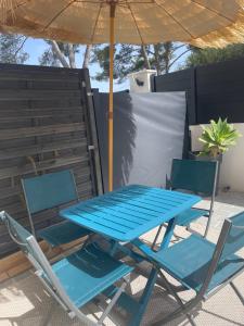 a blue picnic table and two chairs under an umbrella at Bali 83 in Bandol