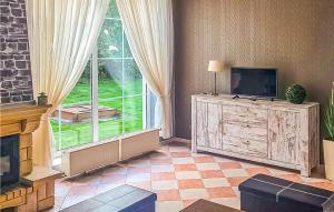 a living room with a television and a large window at 3 Bedroom Awesome Home In Postomino in Postomino