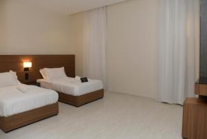 a hotel room with two beds and a television at ارجان بارك القادسية in Riyadh