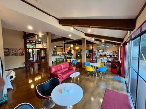 a restaurant with a red couch and tables and chairs at Peace INN HAGI in Hagi