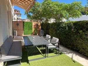 a patio with a table and chairs on the grass at Doris Beach apartment D06 in Burgas City
