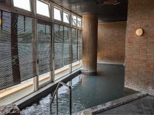 a pool of water in a building with windows at Kochoran in Toba