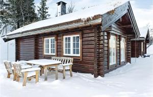 a cabin in the snow with a table and chairs at Holiday Home Flå Øvre Reinsjøfjell in Stamn