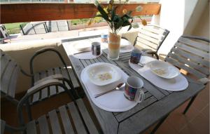 a table with plates and mugs on top of it at Nice Apartment In Benalmádena Costa in Benalmádena