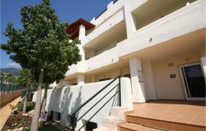 a white building with a tree in front of it at Nice Apartment In Benalmádena Costa in Benalmádena