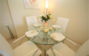 a glass table with a vase of flowers on it at Nice Apartment In Benalmádena Costa in Benalmádena +6 photos