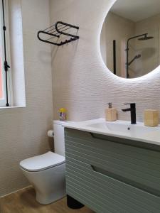 a bathroom with a sink and a toilet and a mirror at los Ojos de Bel in Trevías +18 photos