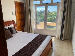 Un dormitorio con una cama y una puerta corrediza de vidrio. en Blue Bay Holiday Resort, en Blue Bay