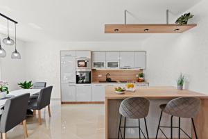een keuken met witte kasten en een tafel en stoelen bij Villa Putina in Brajkovići