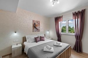 een slaapkamer met een groot bed met twee handdoeken erop bij Villa Putina in Brajkovići +22 foto's