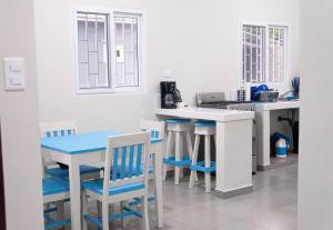 una cucina bianca con tavolo e sedie blu di Blue Casita en Tela a Tela