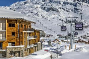 a ski lodge in the snow with a ski lift at Homency - Résidence Daria-i-Nor 202 in L'Alpe-d'Huez