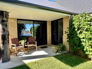 Banksia BeachKarma Waters at Bribie Island的有两把椅子和一张桌子的露台