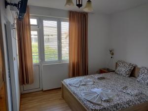 a bedroom with a bed and a large window at Къща за гости Янка in Nesebar