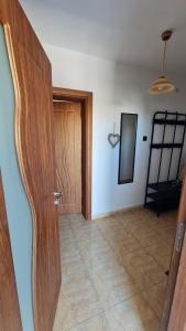 a room with a wooden door and a chair at S Apartment in Tsarevo