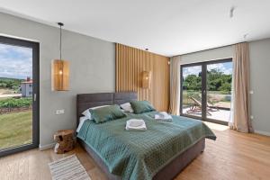 ein Schlafzimmer mit großem Bett und großem Fenster in der Unterkunft Lazy Olive in Vrsar