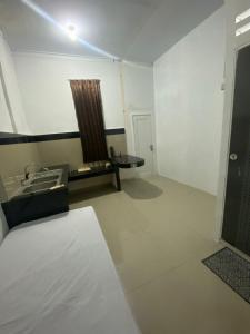 a bathroom with a sink and a table in a room at Kamar Kost in Delitua