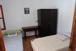 a bedroom with a bed and a black cabinet at Stanza a Formentera in Sant Ferran de Ses Roques