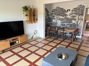 a living room with a flat screen tv and a table at La terrasse de Sancerre in Saint-Satur